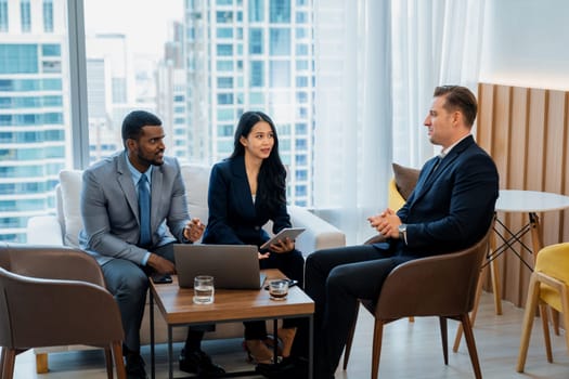 African businessman present start up project to expert investor. Group of multicultural business team solving problems, discussing business idea with skyscraper at modern business lounge. Ornamented