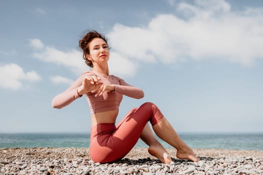 Young woman with long hair in white swimsuit and boho style braclets practicing outdoors on yoga mat by the sea on a sunset. Women's yoga fitness routine. Healthy lifestyle, harmony and meditation