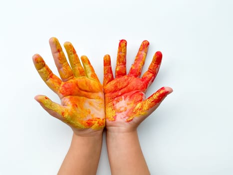 Childrens hands painted with yellow and red paint on white background. High quality photo