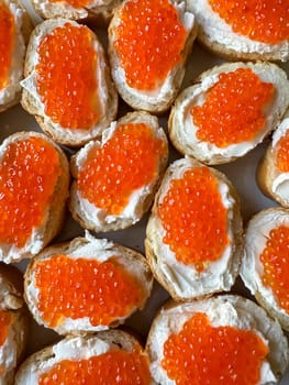 Baguette sandwiches with red salmon caviar and cheese. Top view. High quality photo