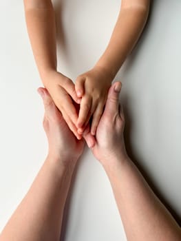 Mothers hands holding childs hands on white background. High quality photo