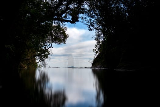 A breathtaking view of the Janela de Ceu door to heaven, where the river flows down to nothingness, revealing the stunning skyline reflection and surrounded by lush greenery.