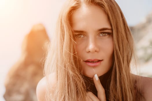 Woman travel sea. Young Happy woman in a long red dress posing on a beach near the sea on background of volcanic rocks, like in Iceland, sharing travel adventure journey