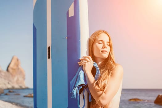 Close up shot of happy young caucasian woman looking at camera and smiling. Cute woman portrait in bikini posing on a volcanic rock high above the sea