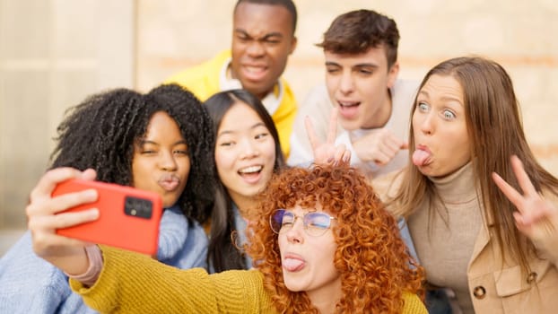 Multiethnic friends having fun on the street taking a selfie being crazy