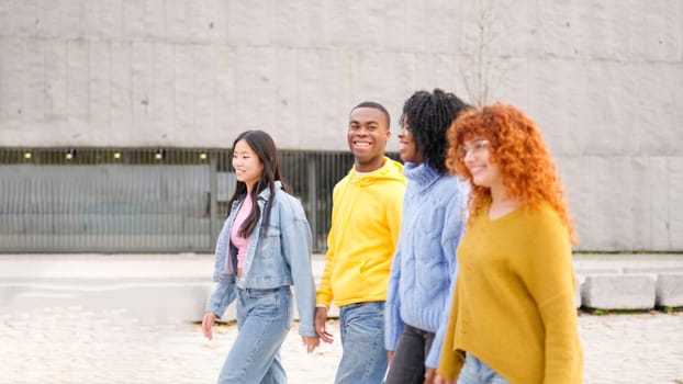 Multiracial friends smiling while strolling along the street