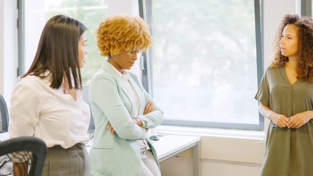 Woman scolding multi-ethnic colleagues in the office of a coworking