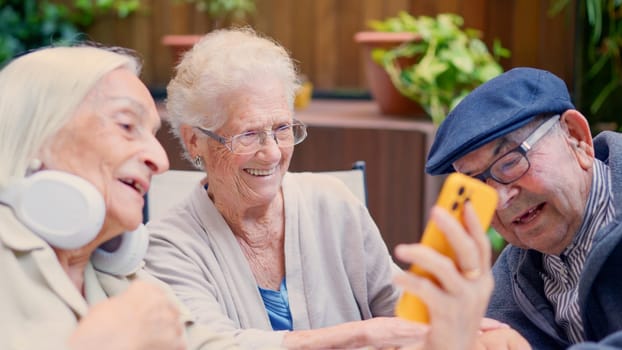 Three senior people of a geriatric using phone and smiling