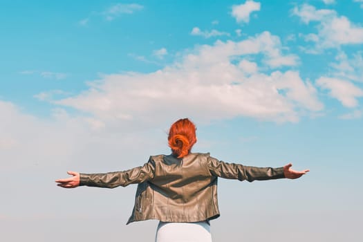 Beauty woman outdoors enjoying nature. Young happy female behind the blue sky