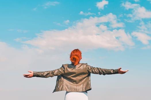 Beauty woman outdoors enjoying nature. Young happy female behind the blue sky