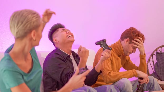 An hispanic man celebrating that wins playing console with friends at home