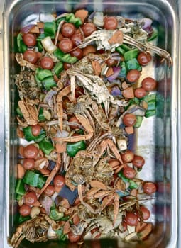Delicious crab salad with paprika, tomatoes, peppers and onions in a plastic container. Top view, close-up