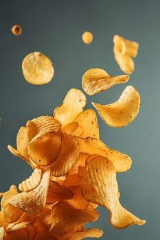 Crispy potato chips floating mid-air with a teal background.