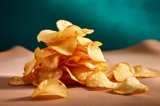 Piled of crispy potato chips against dark background