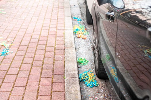 Close up colorful confetti and streamers at the street after Carnival parade