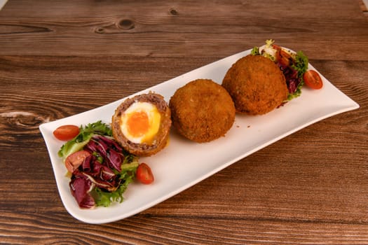 RECIPE FOR BREADED BEEF MEATBALLS STUFFED WITH A SOFT BOILED EGG. High quality photo