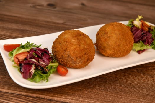 RECIPE FOR BREADED BEEF MEATBALLS STUFFED WITH A SOFT BOILED EGG. High quality photo