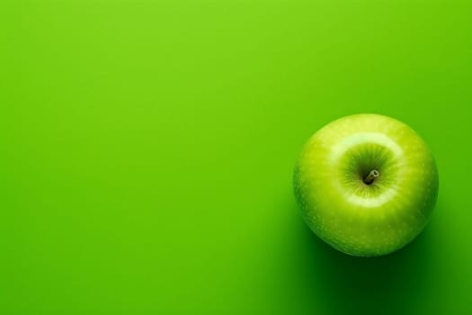 Green apple on a vibrant green background, shot from above.