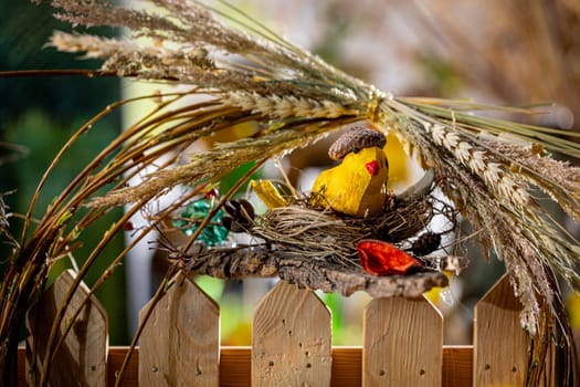 Capture the essence of springtime with this delightful photograph featuring a handcrafted bird's nest nestled on a bright wooden fence.