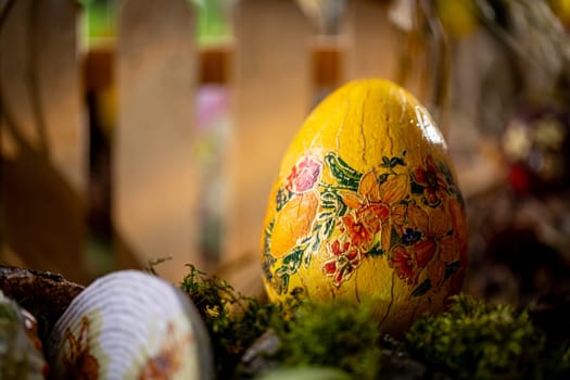 In this composition, a vibrant yellow Easter egg adorned with painted flowers takes center stage, delicately placed on a bed of lush green moss. The yellow color of the egg is vivid and uniform, evoking the joyous spirit of the season.