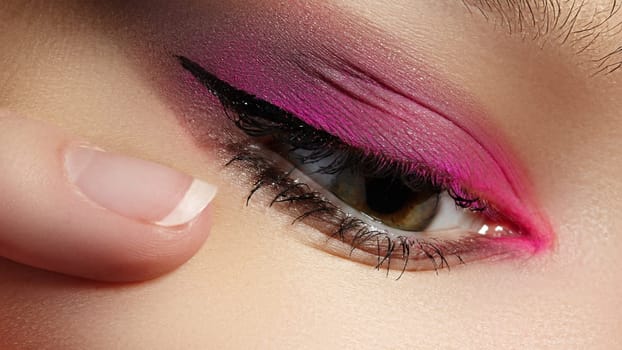 Beautiful macro shot of female eye with classic eyeliner makeup. Perfect shape of eyebrows, brown eyeshadows and long eyelashes. Cosmetics and make-up. Closeup macro shot of fashion liner eyes visage