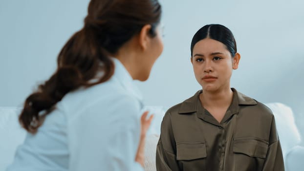 Sad PTSD woman patient in therapy for mental health with psychologist, depression or grief after life failure. Frustrated trauma young woman talking to vivancy psychologist about emotion in clinic