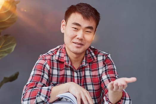 Handsome man propping his chin with his hands while sitting at the table in the office