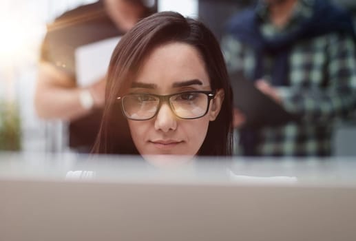 Confident business woman in casual clothes sitting in the office and working on a laptop