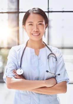 asian doctor standing with crossed arms in hospital