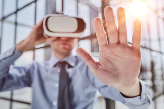 young man testing VR glasses or goggles sitting in the office room