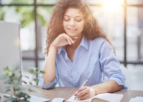 Business woman holding pens and papers making notes in documents on the table