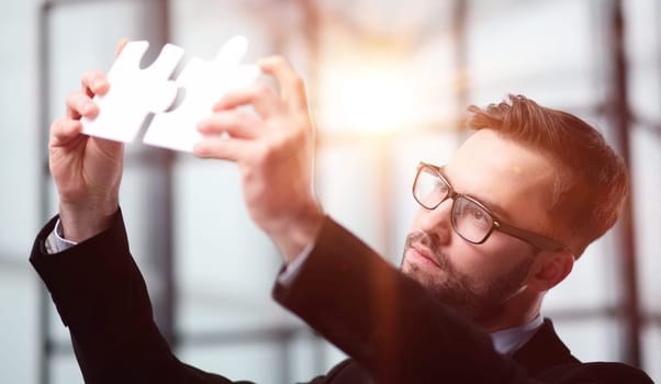 businessman show white jigsaw in hand, business strategy concept