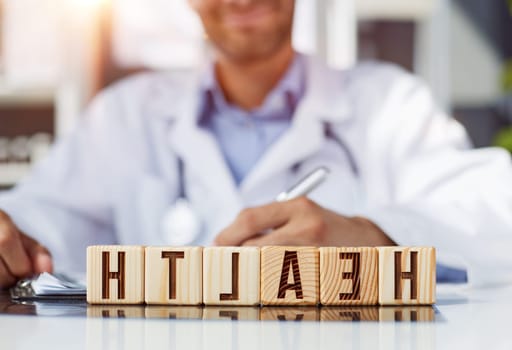 the doctor folded the word healthy from wooden cubes on the table