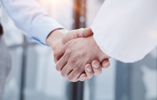 Business partnership meeting in office. Close up of handshake in the office.