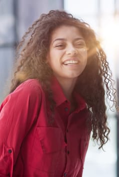 Image of young beautiful joyful woman smiling while working with laptop in office