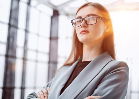Portrait of a confident young businesswoman standing with her arms crossed in an office.