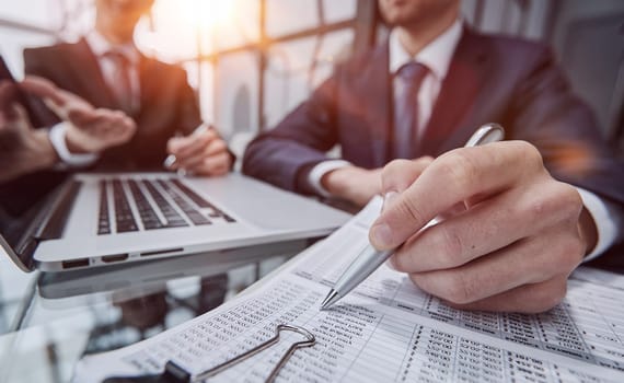 Close up businesspeople cooperate work together discussing company financial statistics