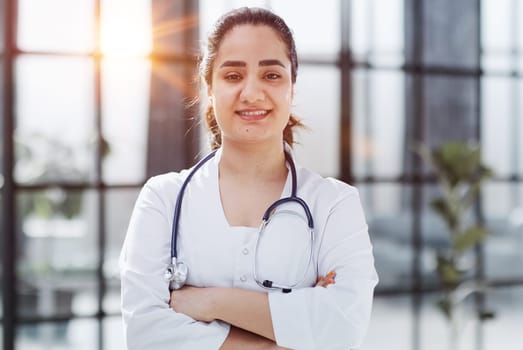 Dentist woman standing with crossed arms. Confident dentist standing in a hospital corridor in a white coat. Generative AI