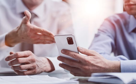 managers read text message on mobile phone in office.
