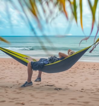 A Man Enjoying A Nap In A Hammock On A Beach In Hawaii