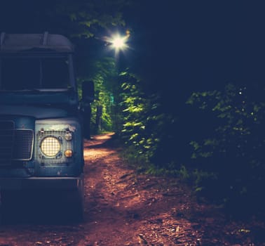 An Off-Road Vehicle Driving A Forest Trail At Night With Copy Space