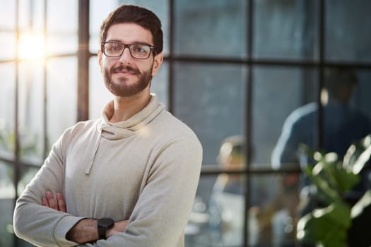 Leading my team to success. Handsome young businessman in smart casual wear keeping arms crossed and smiling