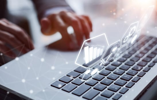 man's hands typing on laptop keyboard in interior