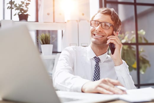 Man accountant or business lawyer talking on smartphone with finance paperwork at workplace