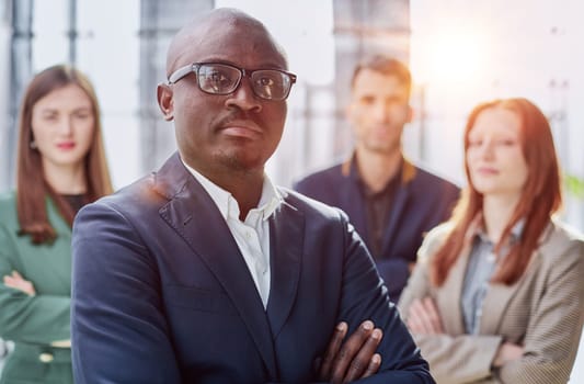 Modern young businessman in formal wear adjusting glasses looking at camera while standing in office