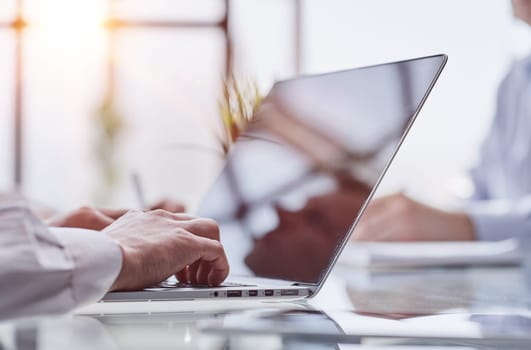 Executive hands typing on laptop at office