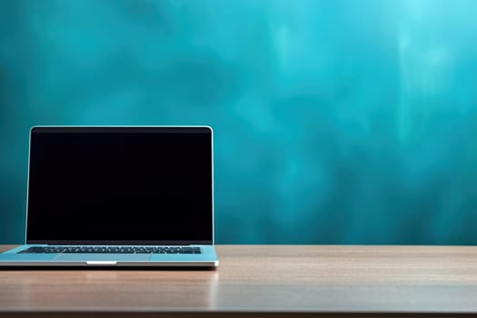 A laptop stands on a wooden table against a blue wall.