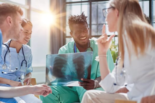 Young group of oral surgeons looking at x-ray while preparing for surgery procedure.