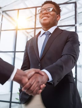 Shot of a young businessman shaking hands with a colleague in the office