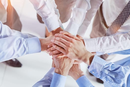 Business people join hands in a circle, top view